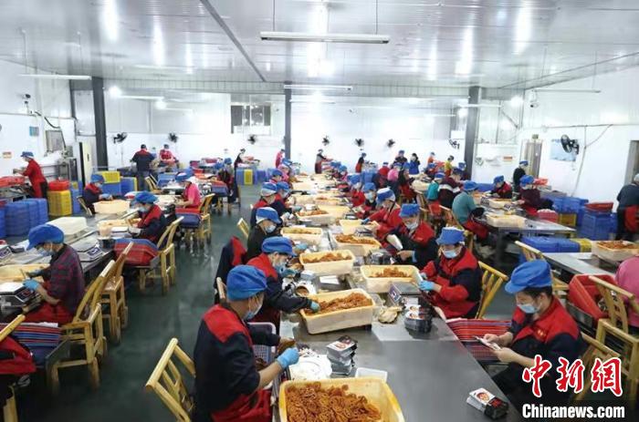 普金公司生产车间内，工人们正在包装卤好的藕片、毛豆等休闲食品。　刘珂 摄