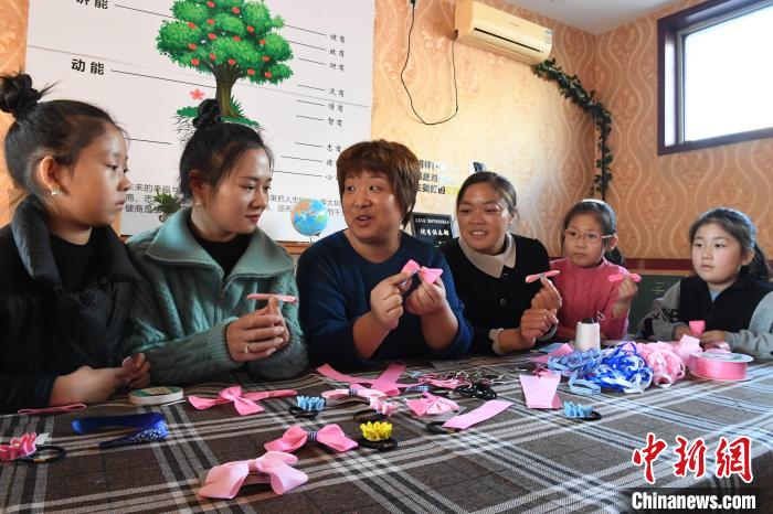 图为最美家庭孵化导师王军响(左三)为乡村家庭妇女培训头饰饰品制作。　刘亮 摄