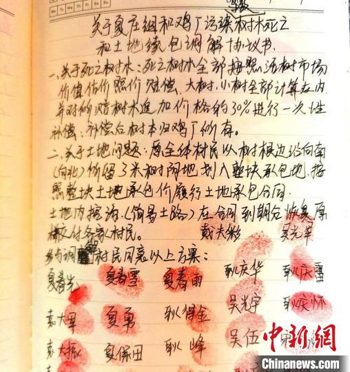 刘帅强在走访笔记本上起草协议书，32户村民按上“红手印”。　顾士刚 摄