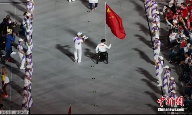 资料图：9月5日，第16届夏季残疾人奥运会闭幕式在日本东京举行。图为中国代表团旗手、女子轮椅篮球运动员张雪梅持五星红旗进入体育场。