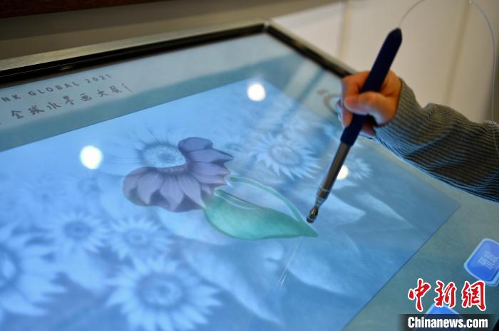 参观展览人士使用多媒体设备为水墨画作填色。　李志华 摄