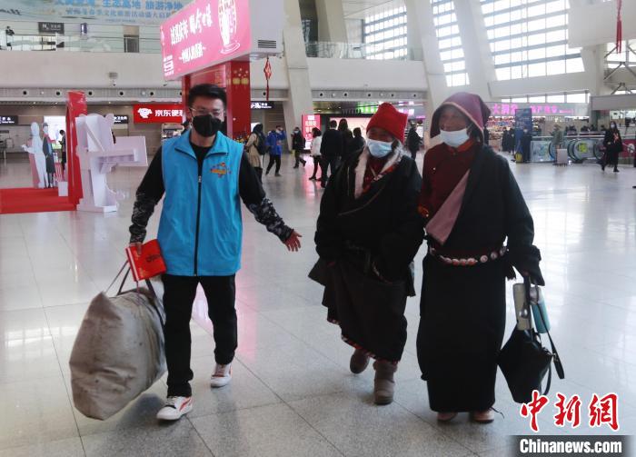 图为志愿者帮助措吉家人拿行李。 马铭言 摄