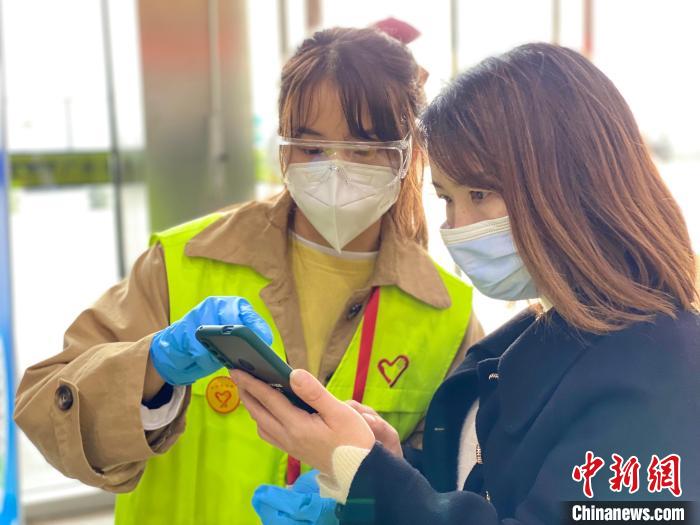青年志愿者颜冬香引导旅客使用软件12306购票 广州电务段供图