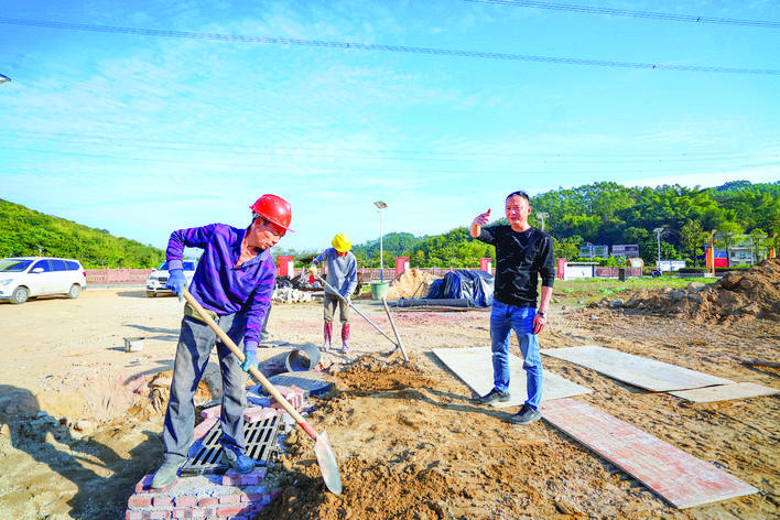 王炯东（右一）查看村民小组宅基地的雨污分流施工进展。（摄影：汤渝杭）