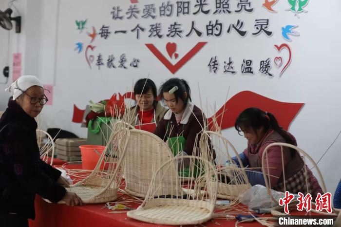 图为江川残疾人集中就业基地，工人编织藤椅。　龚普康 摄