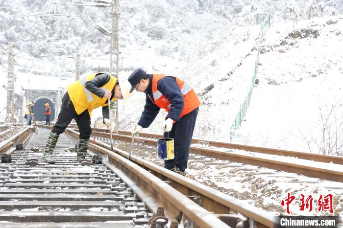铁路职工对道岔设备进行除冰和打油作业。　汤志平 摄