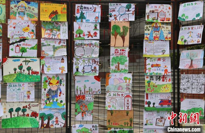 学校操场上展出孩子们亲手创作的森林防灭火宣传画。　四川应急 摄