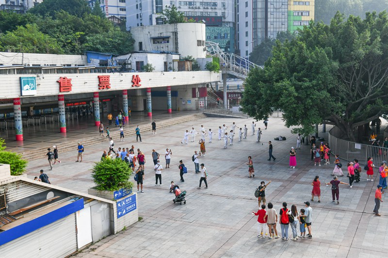 6月19日，人们来到重庆火车站站前广场合影留念。邹乐 摄