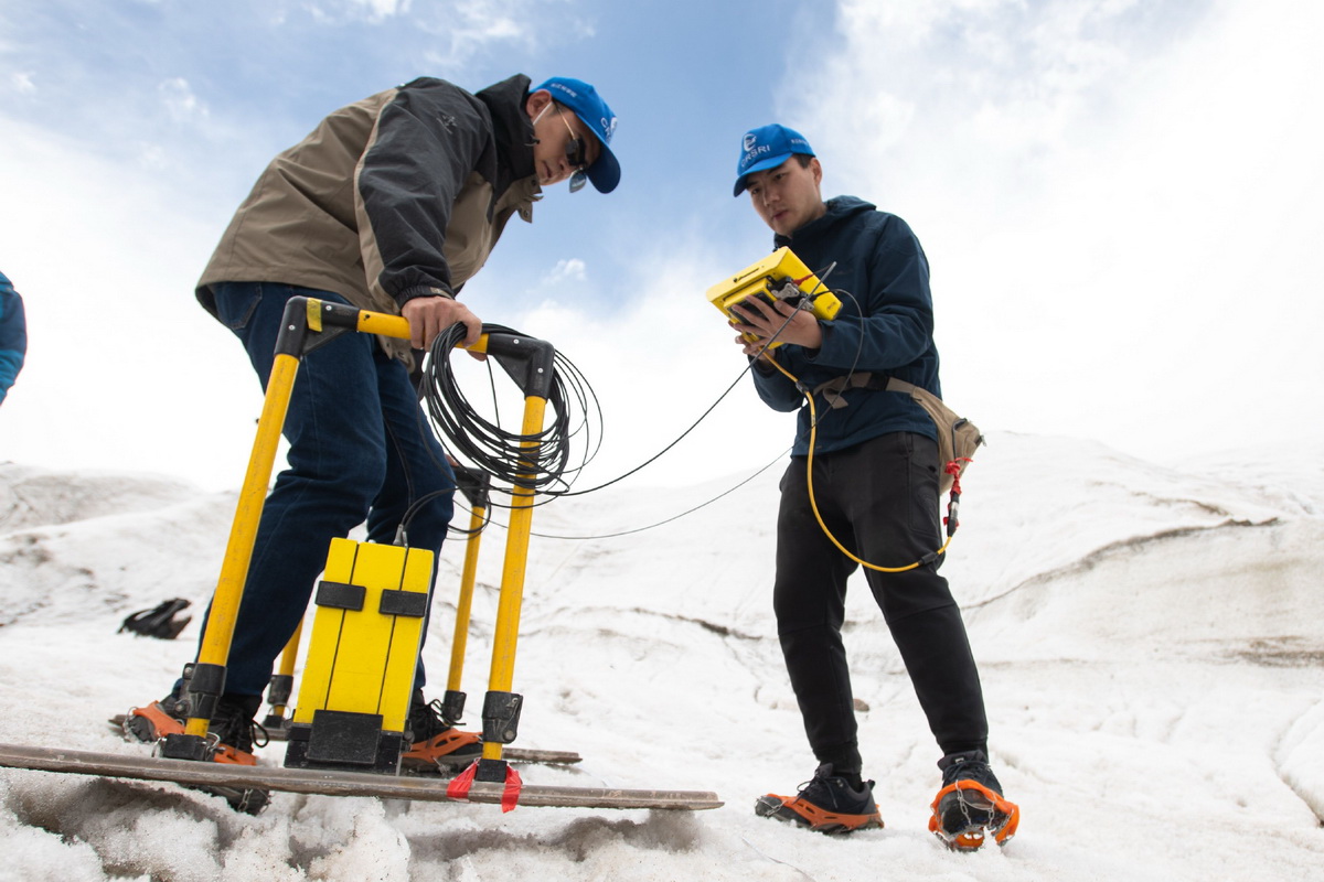 7月28日，在格拉丹东雪山，来自长江科学院的科考队员董士琦（右）和范越使用地质雷达探测冰川。