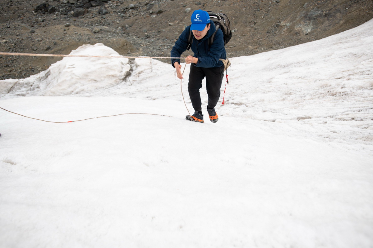 7月28日，在格拉丹东雪山，来自长江科学院的科考队员董士琦在攀爬一处冰川。