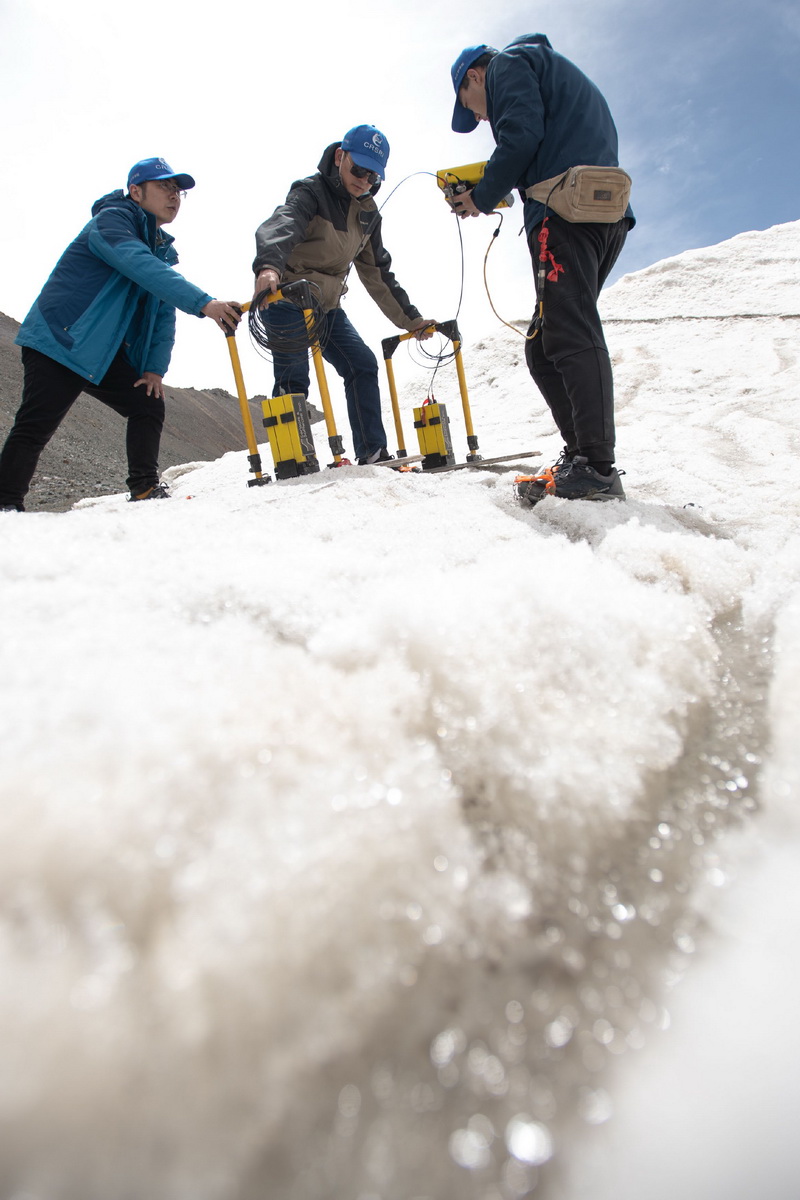 7月28日，在格拉丹东雪山，来自长江科学院科考队员郭辉（左）、范越（中）、董士琦使用地质雷达探测冰川。