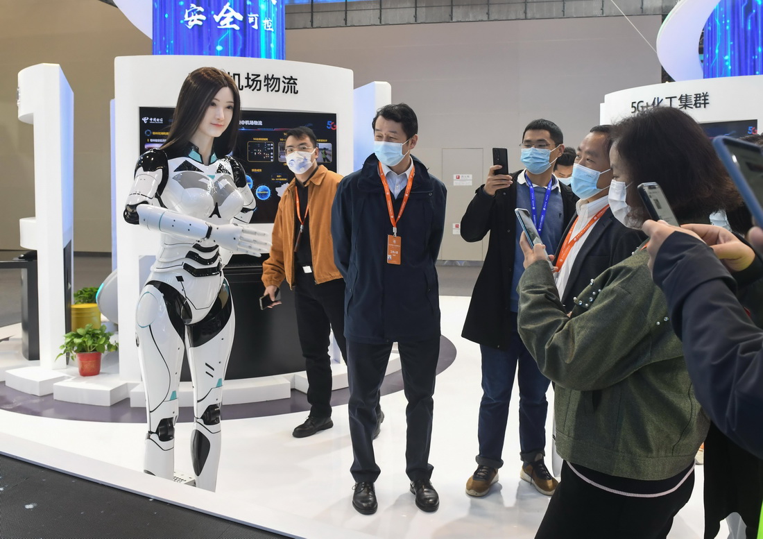 11月20日，参观者在与一款高仿人机器人互动。