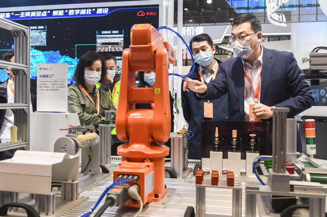 11月20日，工作人员向参观者介绍5G智能工厂生产场景。