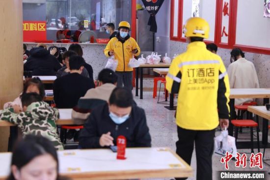 12月1日中午，秦先生经营的螺蛳粉小店，堂食客人慢慢多起来，外卖小哥川流不息.　陈岁丰 摄