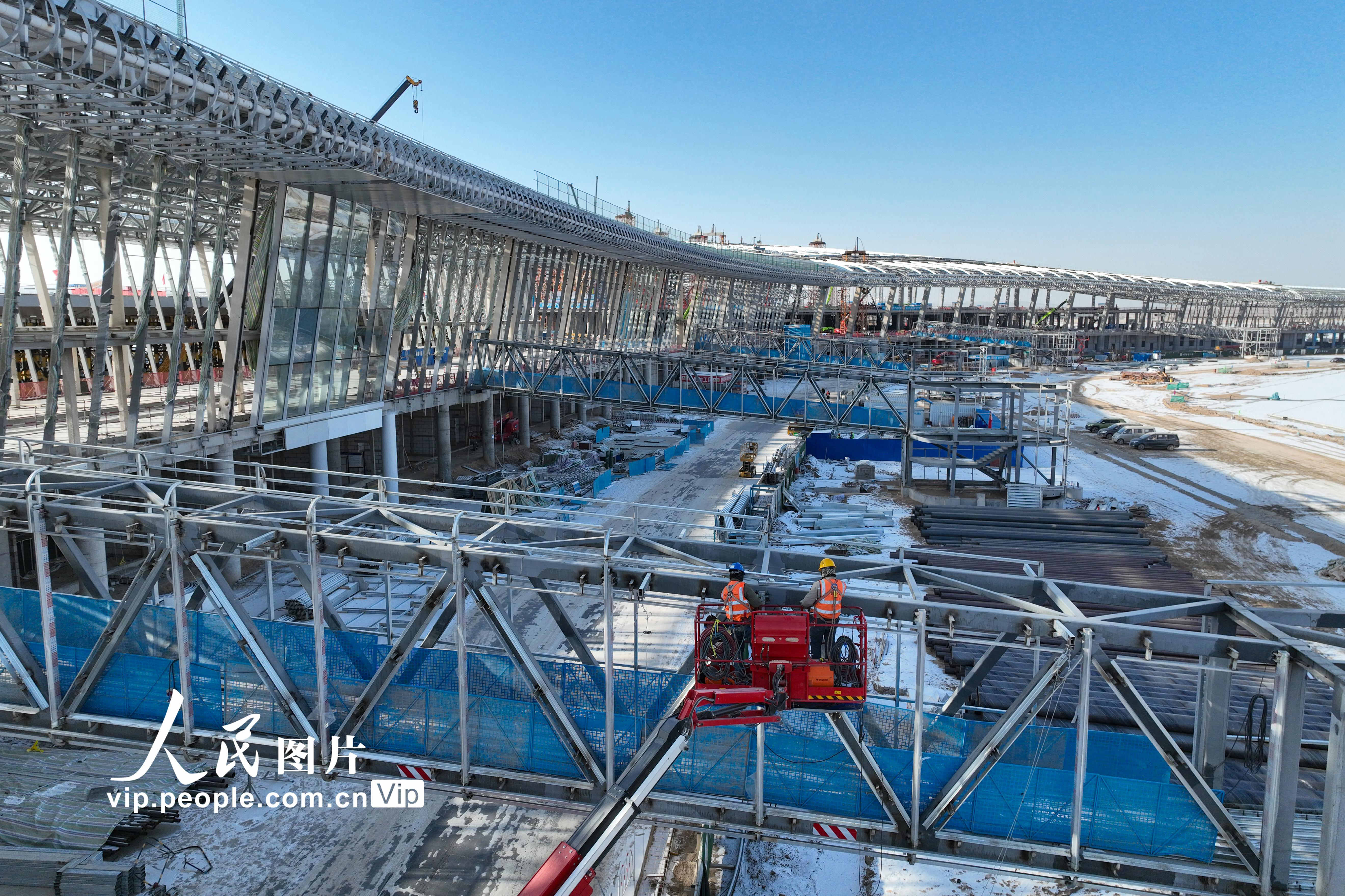 12月20日，甘肃兰州中川国际机场三期扩建工程工人正冒着严寒抢工期，在廊桥进行钢结构作业。