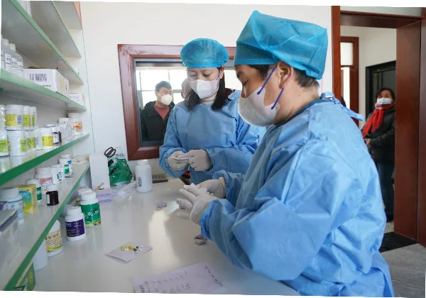 2022年12月22日，在陕西省周至县马召镇富饶村东富饶卫生室内，工作人员在为发热患者包装药品。新华社图