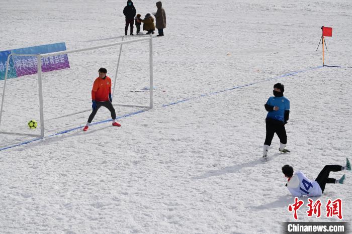 内蒙古呼和浩特市，运动员在雪地足球场倒地射门。　刘文华 摄