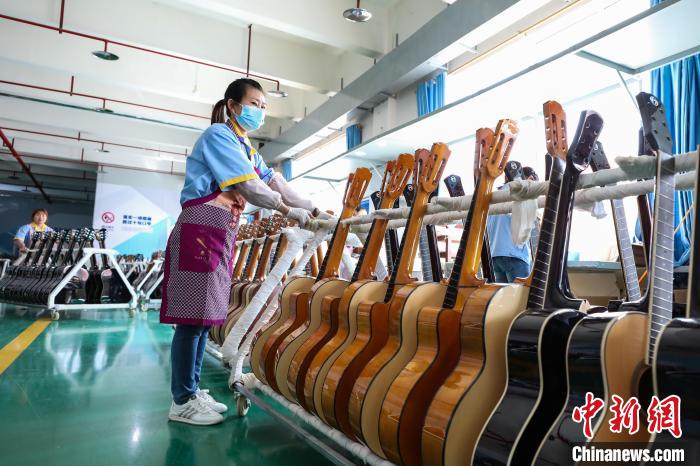 图为贵州正安吉他企业的生产车间，工人忙着转移半成品吉他。　瞿宏伦 摄
