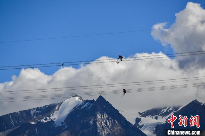 资料图为2020年6月23日,西藏阿里联网工程施工人员在日喀则希夏邦马雪山附近走线作业。 江飞波 摄 资料图为2020年6月23日,西藏阿里联网工程施工人员在日喀则希夏邦马雪山附近走线作业。 江飞波 摄
