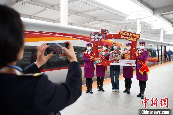 图为旅客在站台与重庆客运段“女车班”列车员合影留念。　何蓬磊 摄