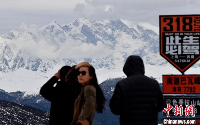 游客打卡西藏林芝色季拉山赏南迦巴瓦峰