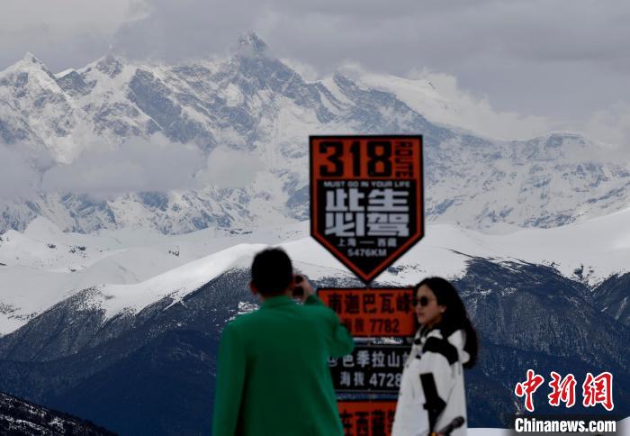 图为5月14日，西藏林芝色季拉山观景台，游客远眺南迦巴瓦峰。　　李林 摄