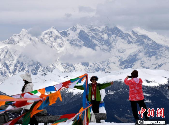 图为5月14日，西藏林芝色季拉山观景台，游客与南迦巴瓦峰合影。　李林 摄
