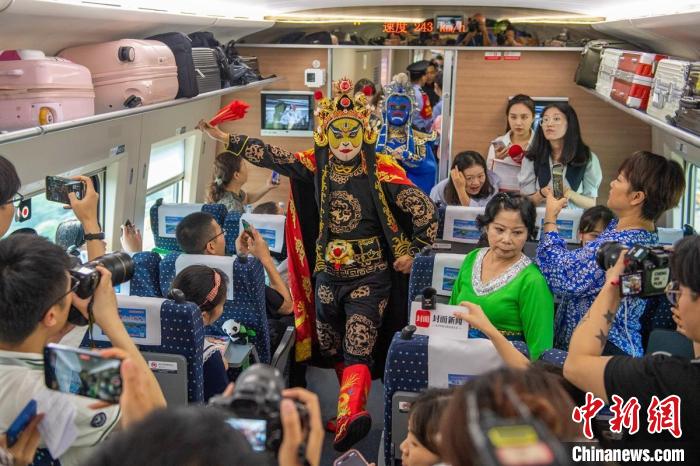 成都直达香港列车上文艺工作者表演川剧变脸，吸引了乘客和媒体。　刘忠俊　摄