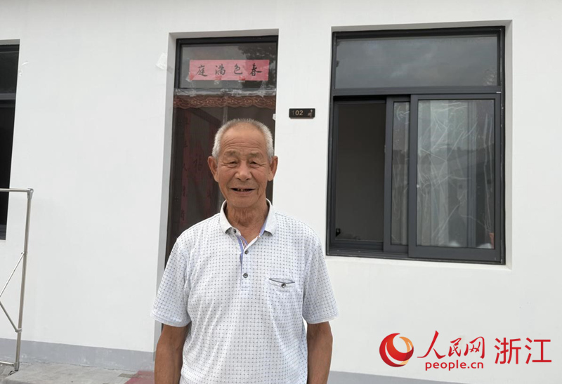 胡根清站在新住所前。人民网记者 方彭依梦摄