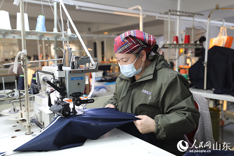 工坊内村民正专注地制作校服。人民网记者 刘祺摄